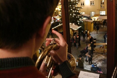 Ein Trompeten-Spieler schaut hinab auf den weihnachtlich erleuchteten Riedenburger Marktplatz mit großem Christbaum.