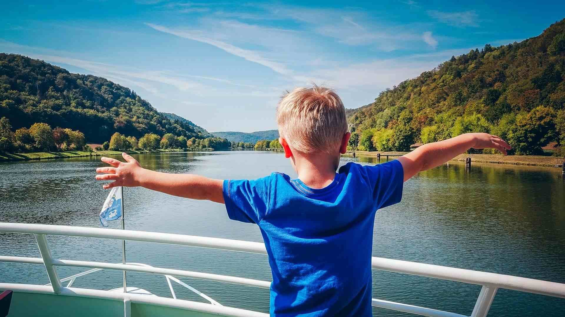 Ein kleiner Junge steht am Bug eines Ausflugsschiffes, das auf der Donau von Kelheim nach Riedenburg fährt.