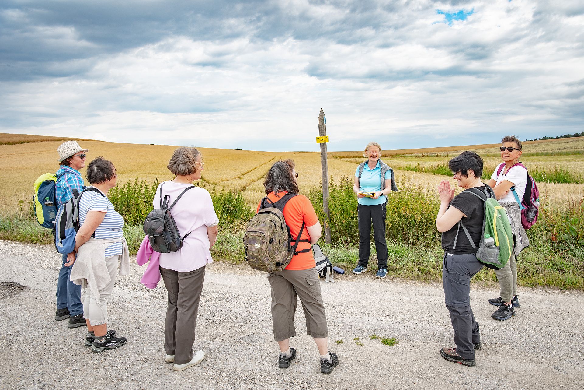 Eine Pilgerwegbegleiterin erklärt einer Wandergruppe die Bedeutung des europäischen Pilgerwegs VIA NOVA.