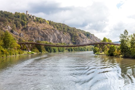 Die Holzbrücke Tatzlwurm verläuft über den Main-Donau-Kanal in Essing. Links auf dem Felsmassiv steht die Burgruine Randeck.