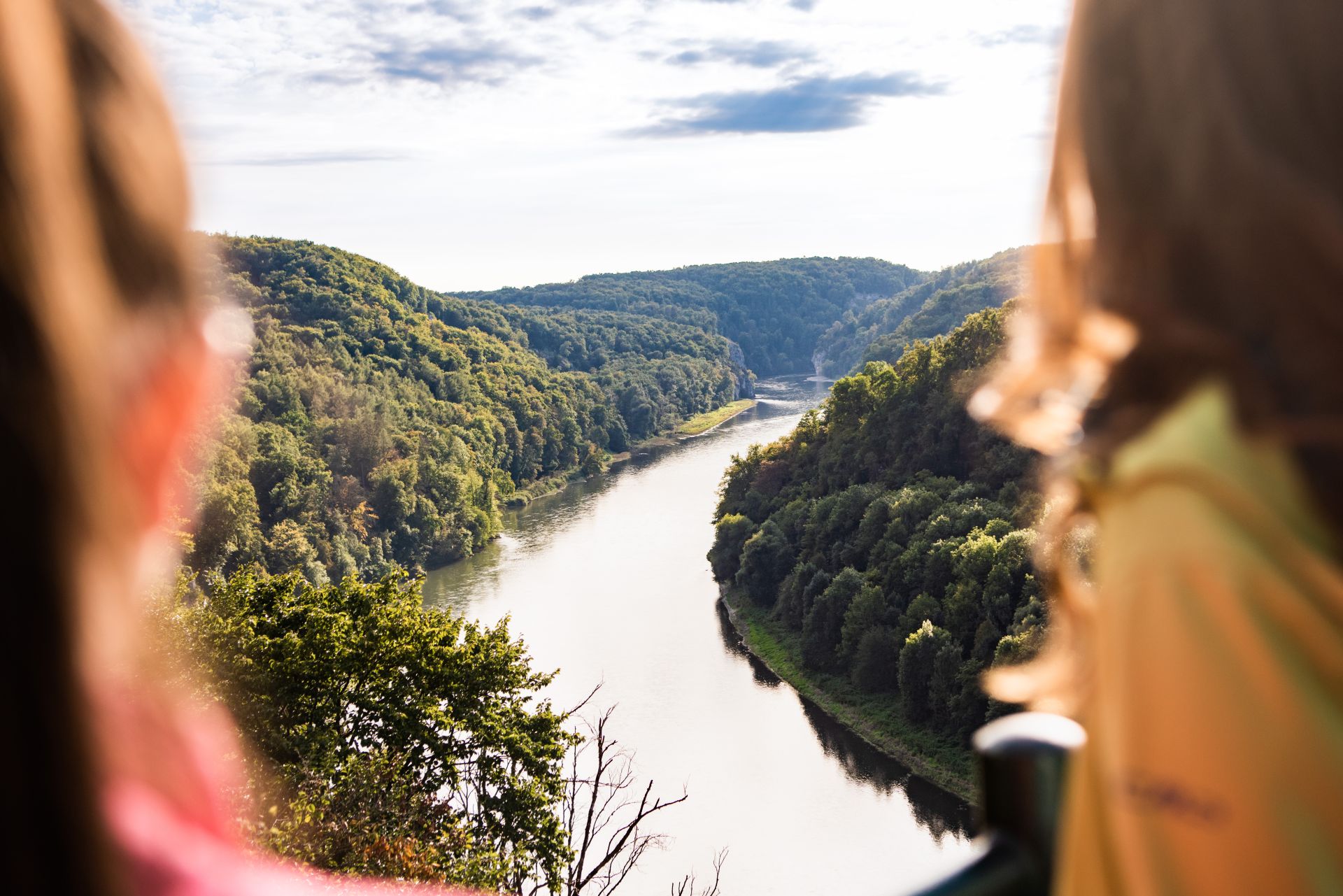 Zwei Wanderer genießen den Ausblick auf die Donau. Sie stehen am Aussichtspunkt am Wieser Kreuz und schauen hinunter auf das Nationale Naturmonument Weltenburger Enge.