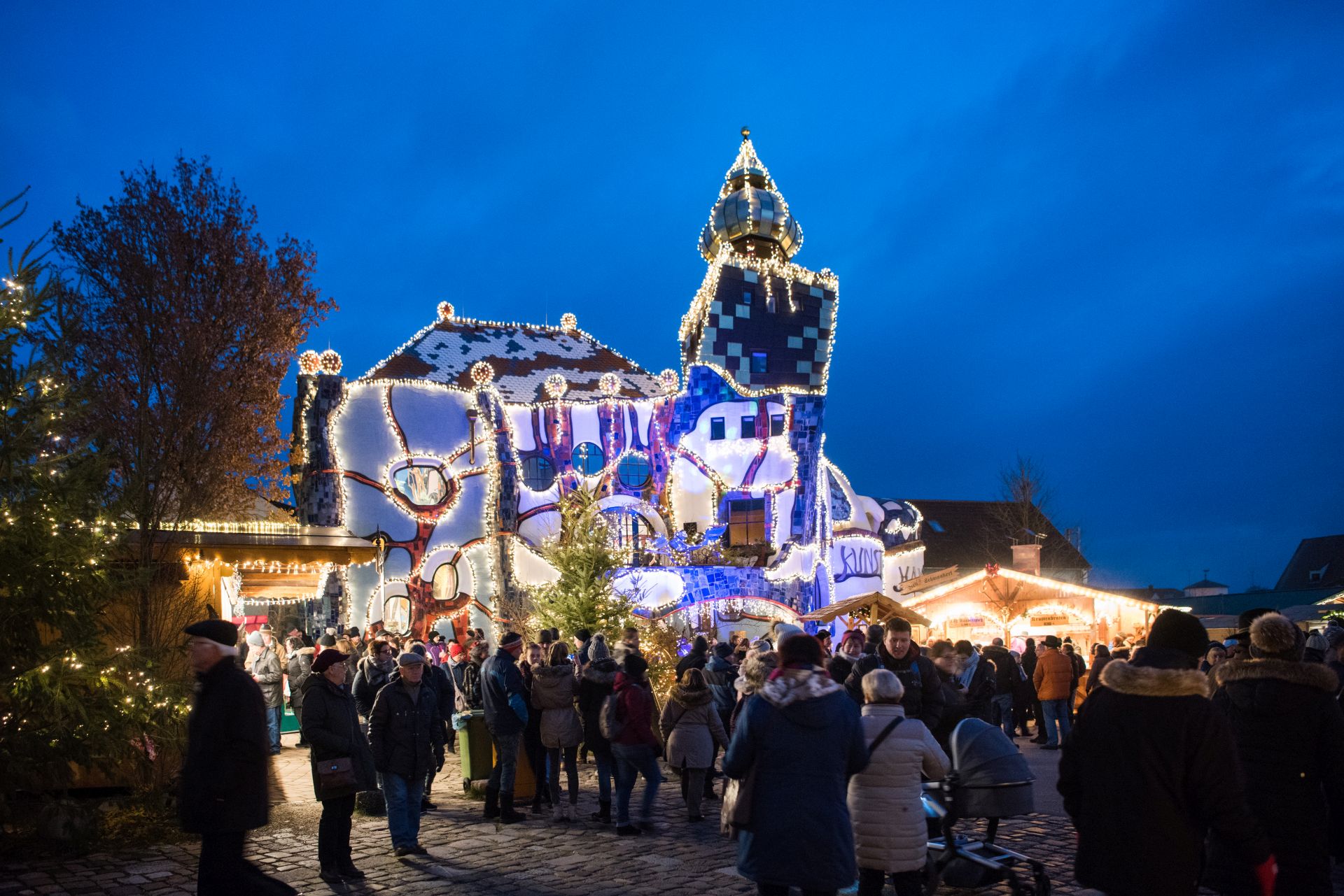Das KunstHausAbensberg in erstrahlt während Kuchlbauers Turmweihnacht in festlichem Glanz und ist umgeben von zahlreichen Weihnachtsständen.