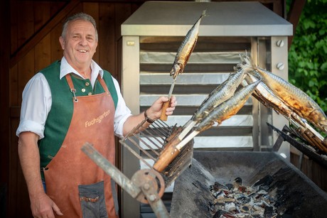 Sepp Fuchs bereitet die Steckerlfisch selbst am offenen Holzkohlegrill zu. Die Makrelen sind eine Spezialität im Fuchsgarten Riedenburg.