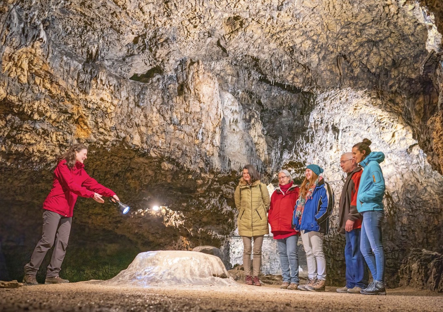 Ein Gruppe steht mit einer Höhlenführerin in der Tropfsteinhöhle Schulerloch im Altmühltal.