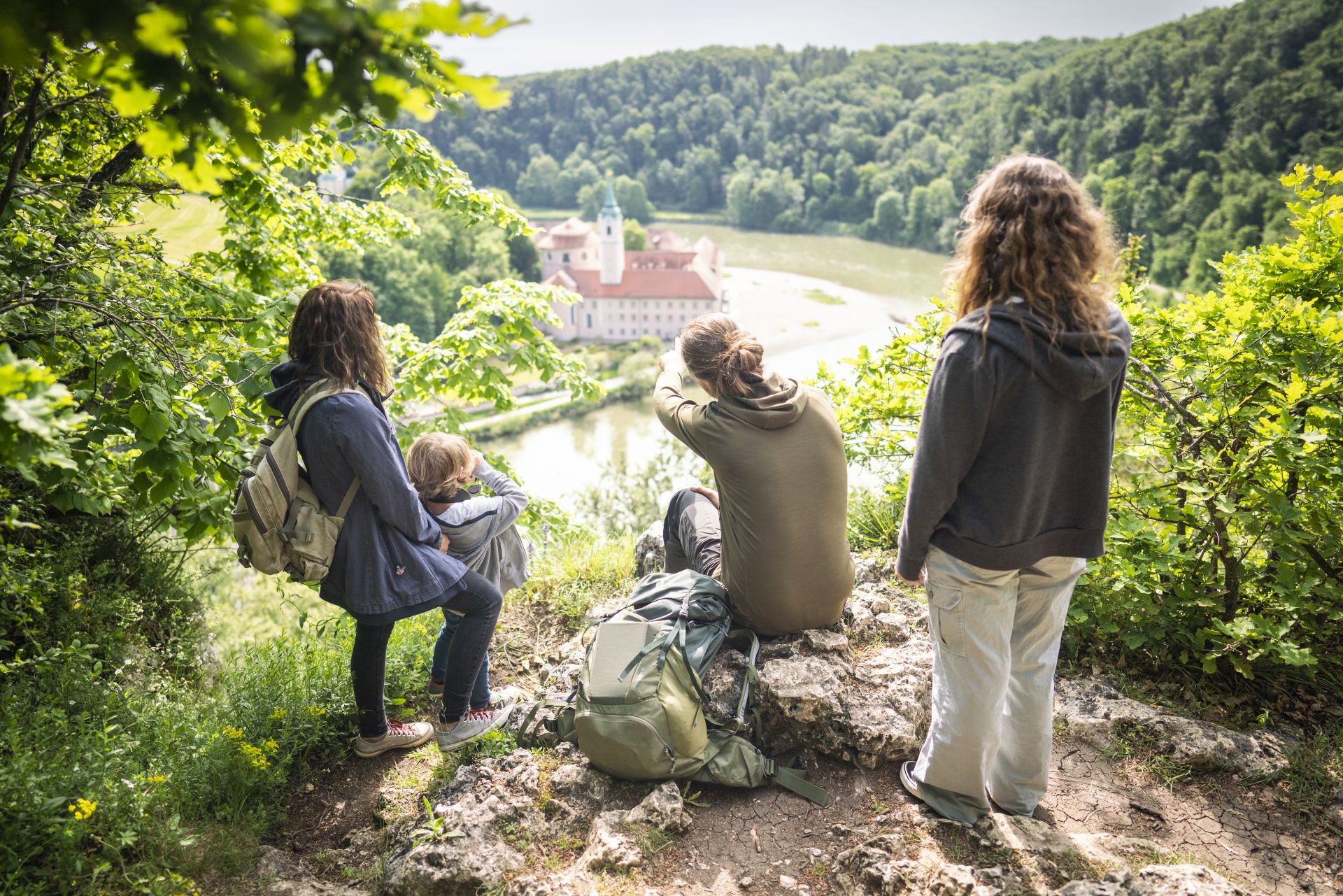 Der Ranger uns zwei Frauen stehen am Aussichtspunkt und blicken auf das Kloster Weltenburg und die Donau.