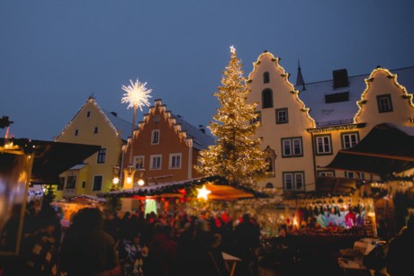 Die bunten Bürgerhäuser der Abensberger Altstadt sind zum Niklasmarkt hell erleuchtet. Ein großer Christbaum strahlt über den Ständen des Weihnachtsmarktes. 