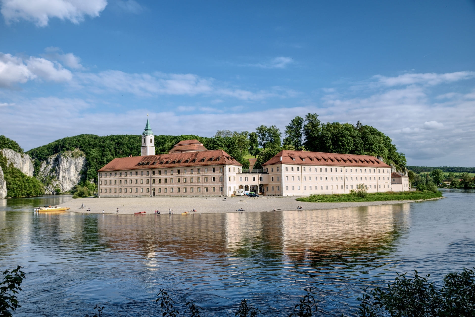 Kloster Weltenburg liegt an der Donau. Im Hintergrund sieht man den Donaudurchbruch mit seinen Felsen.